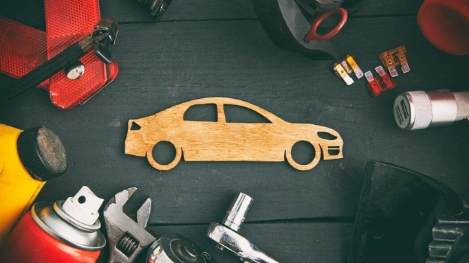 A 2D wooden car with the tools for car repair around it