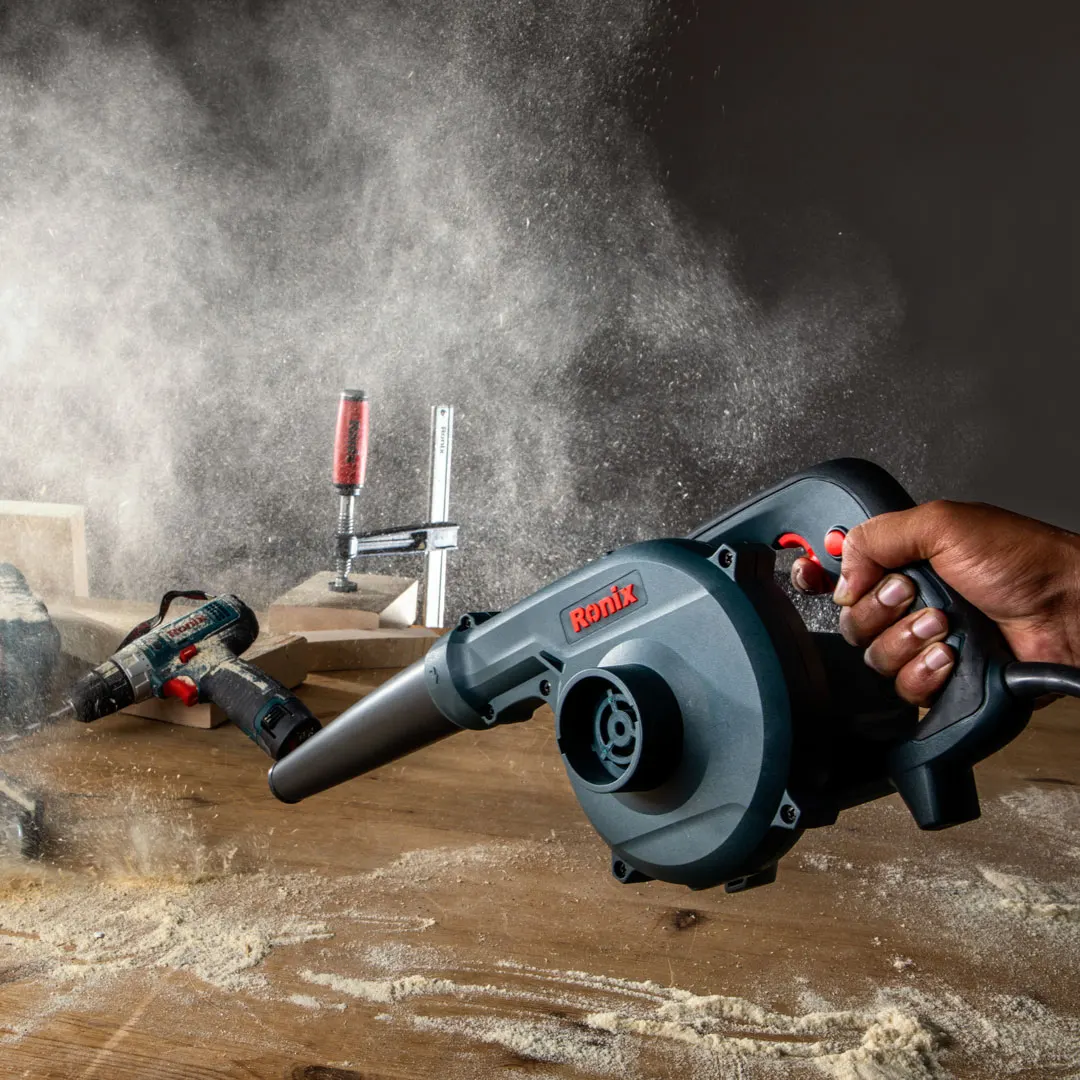 hand of an operator using Ronix dust blower in a workshop