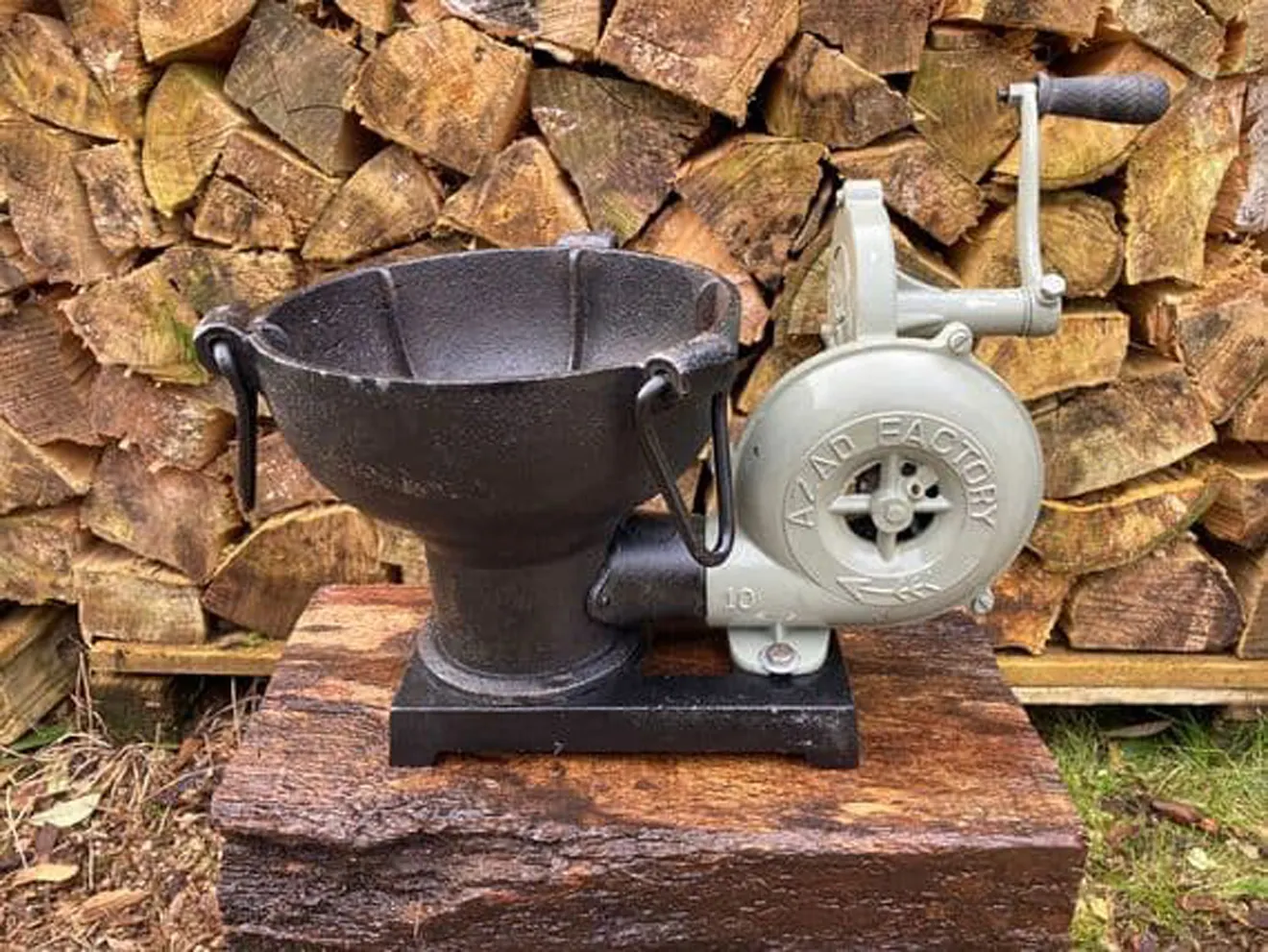 A photo of a hand-cranked forge blower on a wooden stand