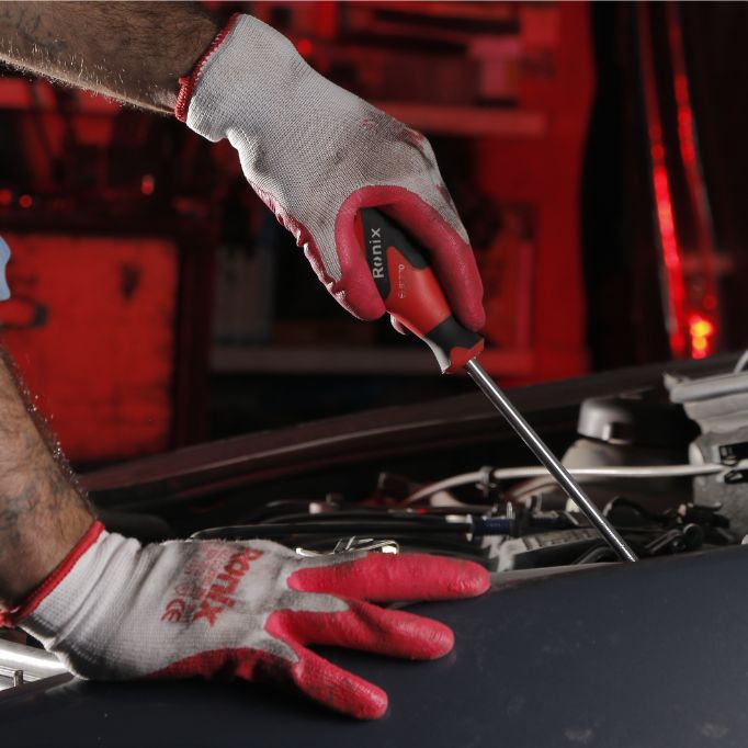 picture of a person using a screwdriver fixing a car
