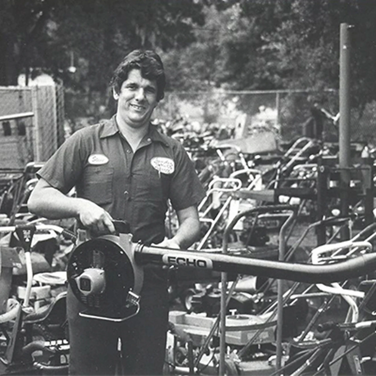 An old photo of a man holding Echo leaf blower in his hands