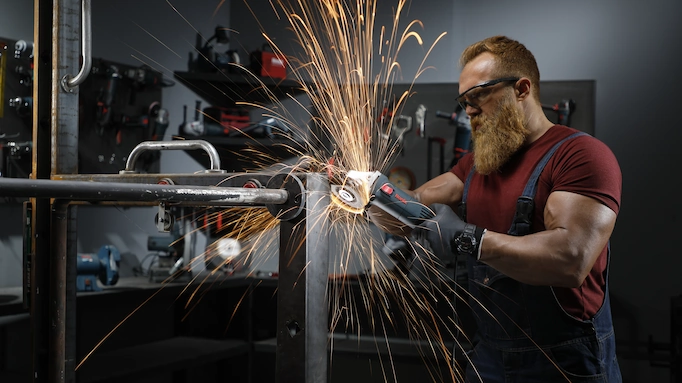 An angle grinder is being used to grind metal