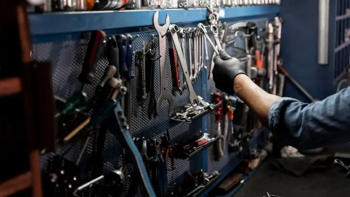 A man putting wrenches on a Wall Mount Tool Organiser
