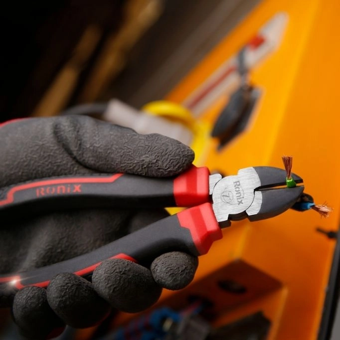 picture of a person with safety glove using a hand tool 