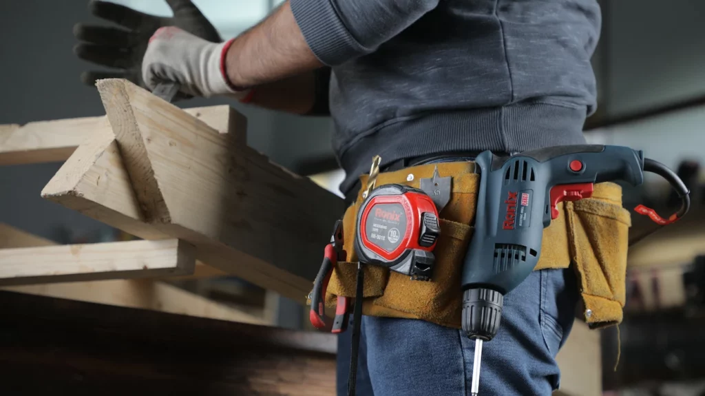 A man wearing a tool belt with all the tools plus text about DIY tools for beginners