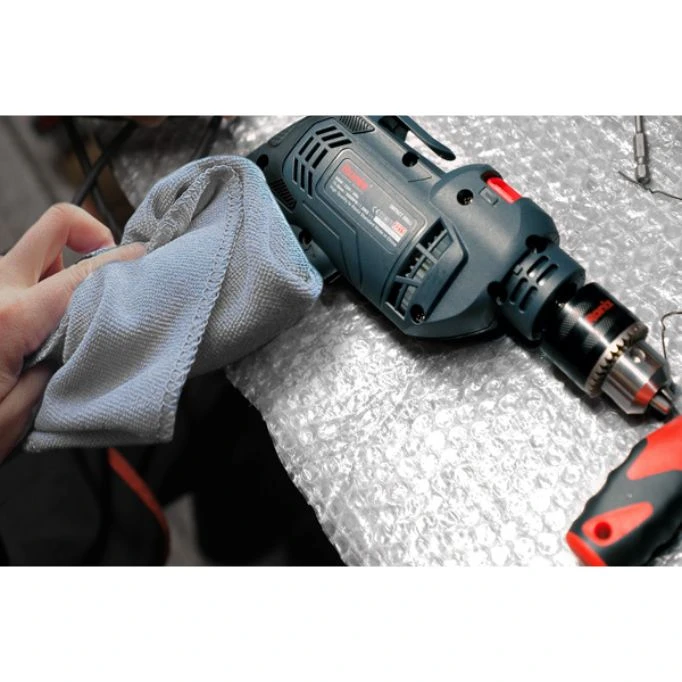 An image demonstrating the process of cleaning a drill as part of power tool maintenance