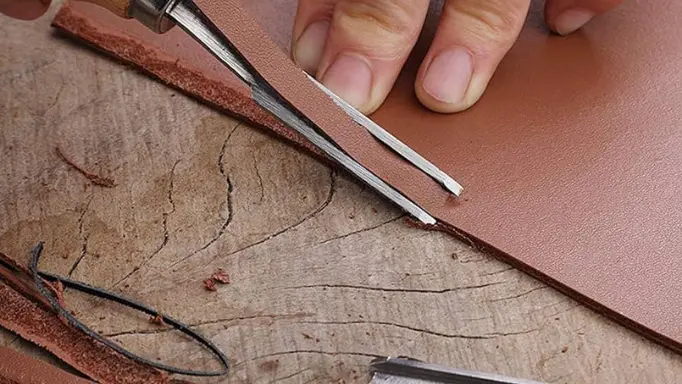 Smoothing the edges of the leather with an edge beveler as one of the professional leatherworking tools