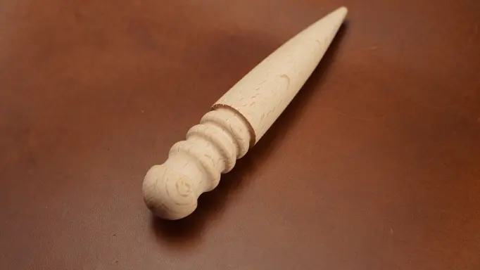 A wooden edge burnisher as one of the professional leatherworking tools 