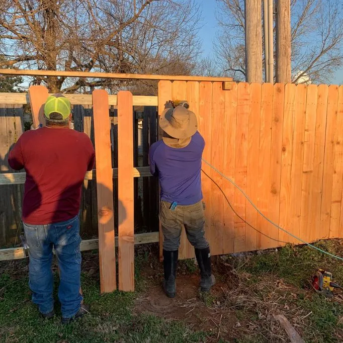 picture of 2 person installing wood fence 