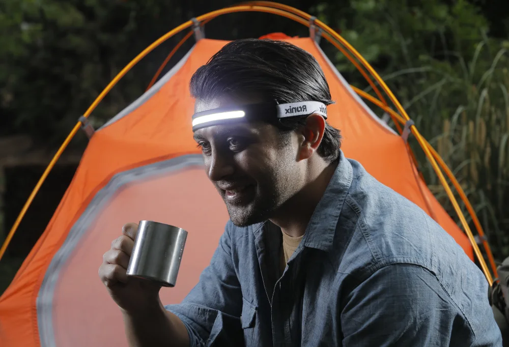 Photo of someone using the best headlamp for camping