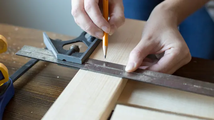 Marking a piece of wood with a ruler and a pen