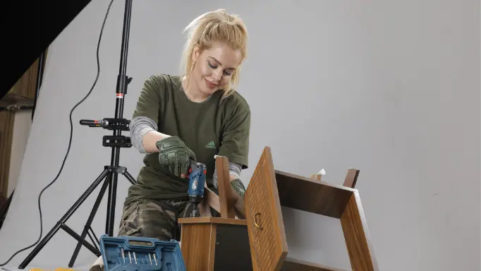 A woman assembling chest of drawers using a Ronix cordless screwdriver