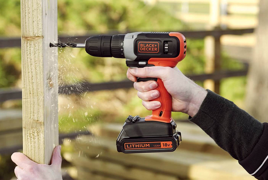 Using a Black & Decker cordless drill to make holes in the wood