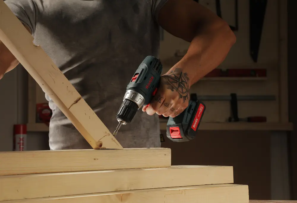 person using Ronix cordless drill to join two pieces of wood