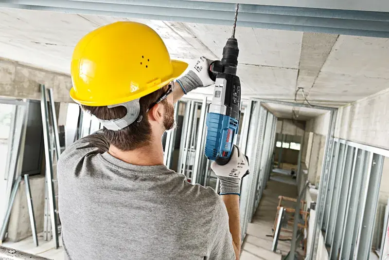 picture of a person using a Bosch rotary hammer drill