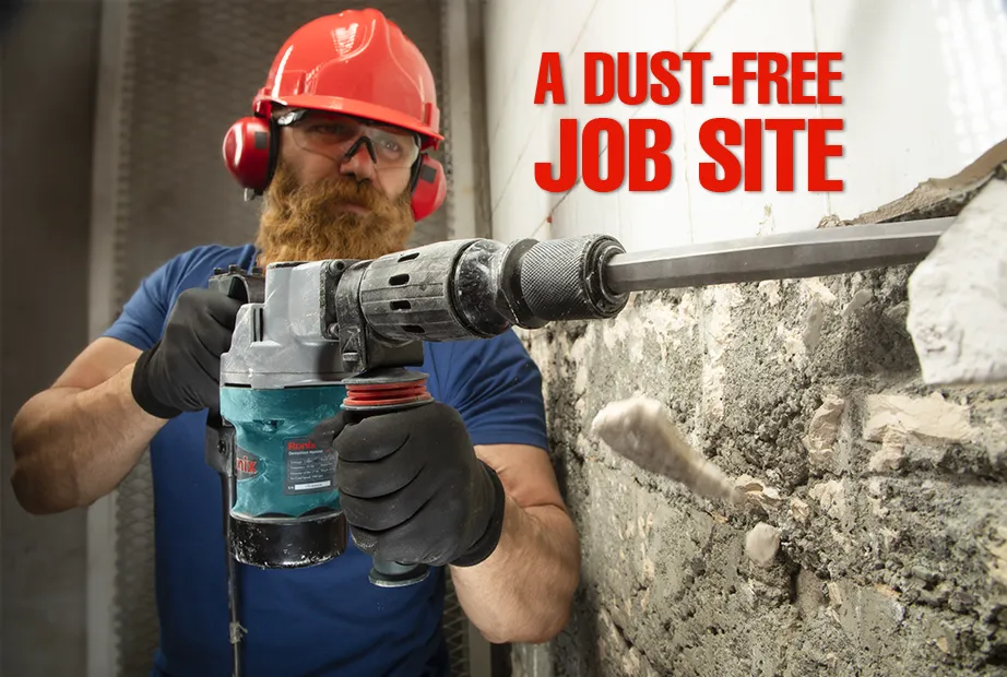A bearded man wearing safety equipment and removing tiles of a wall with jackhammer