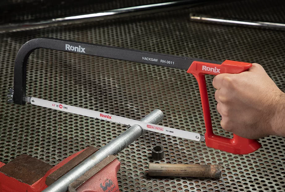 A hacksaw being used to cut a metal pipe