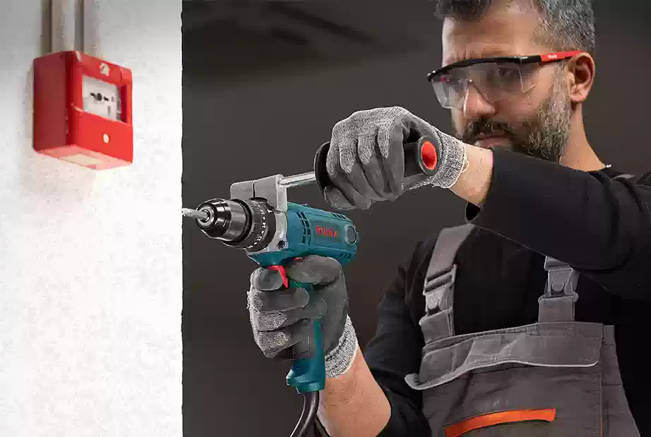 A man using Ronix 2520 impact driver to drill through the wall