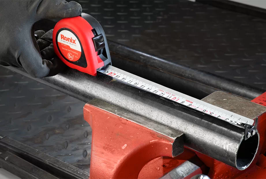 A tape measure is used to measure the length of a piece of pipe