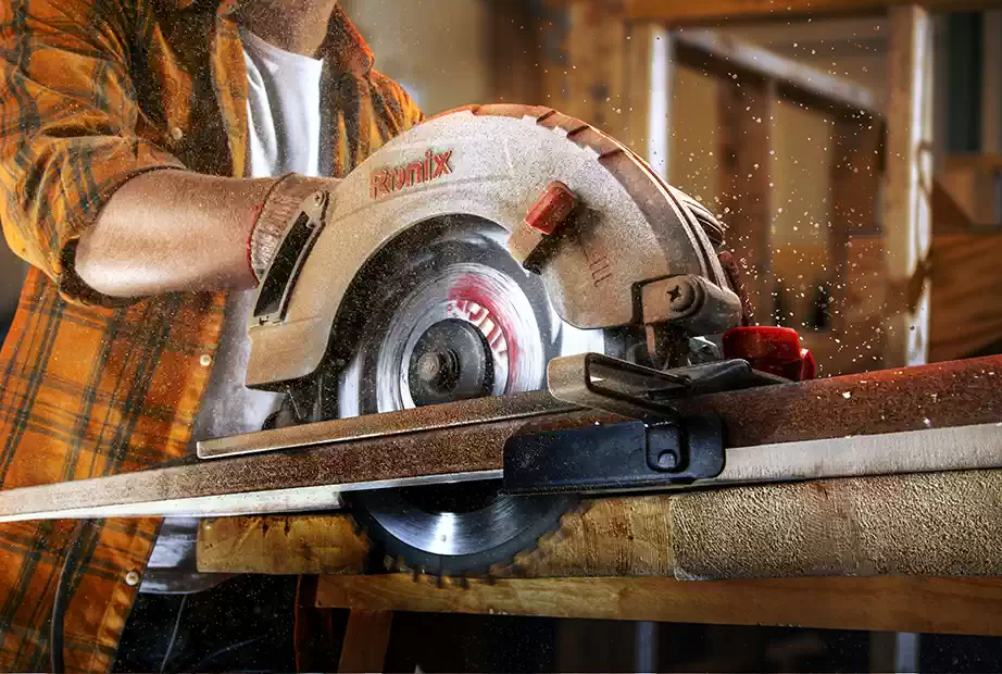 a woodworker is cutting timber with a circular saw
