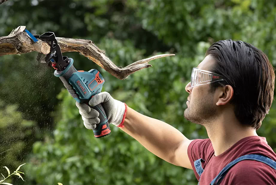 A reciprocating saw cutting branches