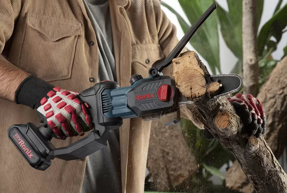 An operator cutting a tree branch with chainsaw