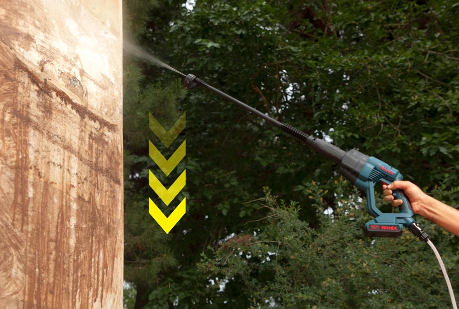 Washing a dirty wall with a high-pressure washer from top to bottom