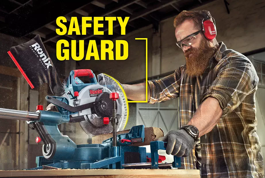 An operator using a miter saw with safety guard