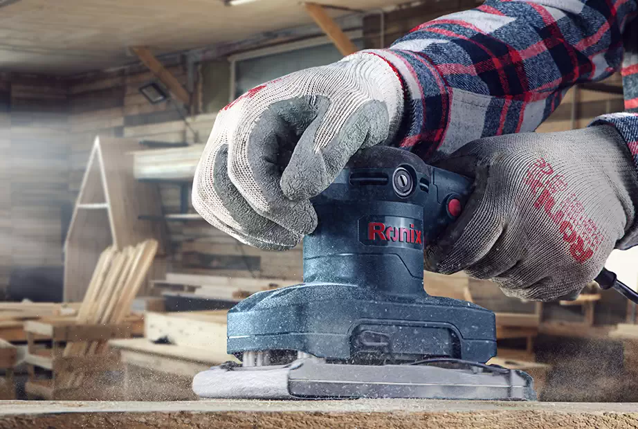 Sanding a wooden surface with a Ronix corded sander