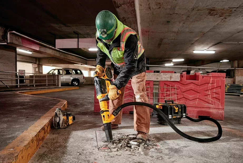 photo of a construction worker using DeWalt jackhammer and dust extractor