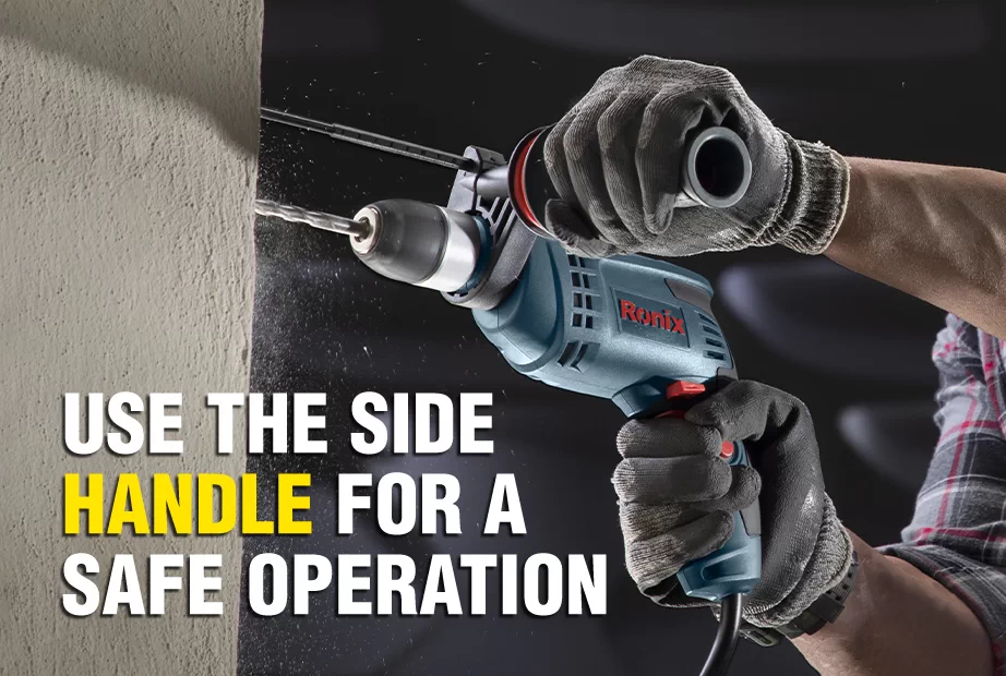 User grabbing the side handle of a hammer drill while using it
