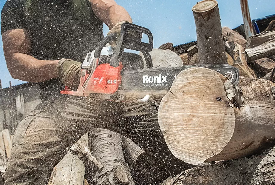 A man cutting a tree by a Ronix chainsaw