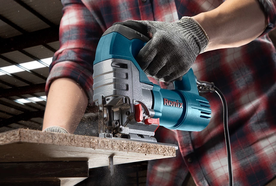  A man using a jigsaw on wood