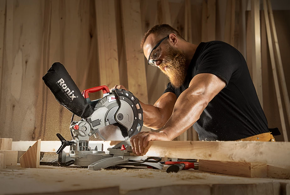 A man using a Ronix miter saw on wood