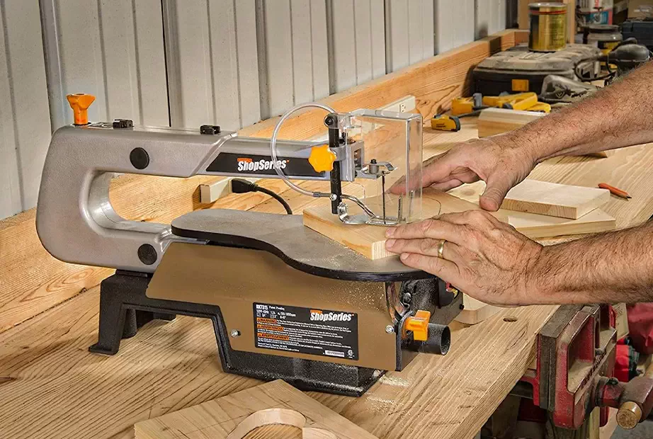 A man using a scroll saw on wood