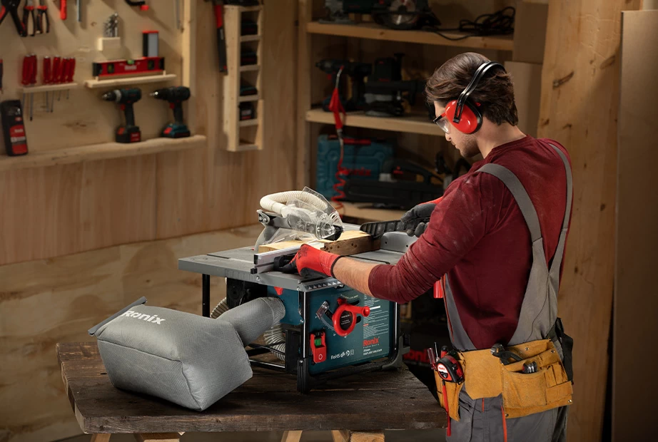 A man using a Ronix table saw on wood