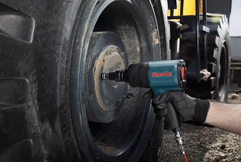 A mechanic using a Ronix air impact wrench on a truck’s tire