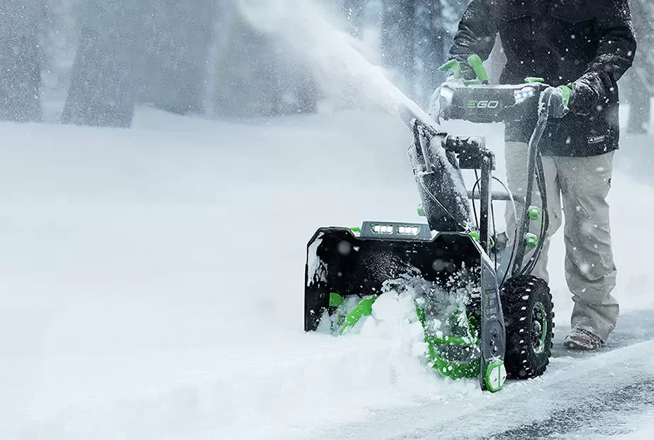 An Ego snow blower is used to clear a driveway
