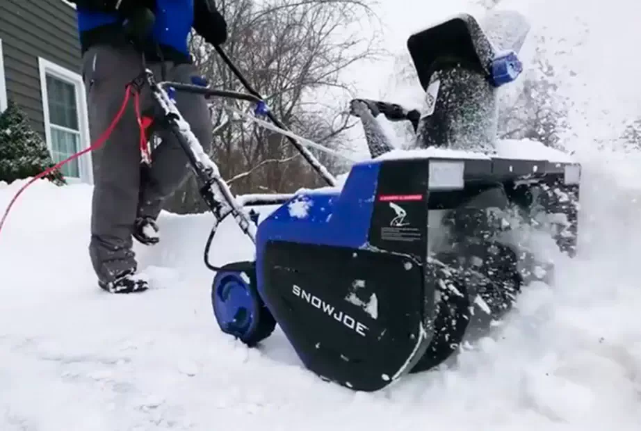 Snow Joe electric snow blower being used to clear a driveway
