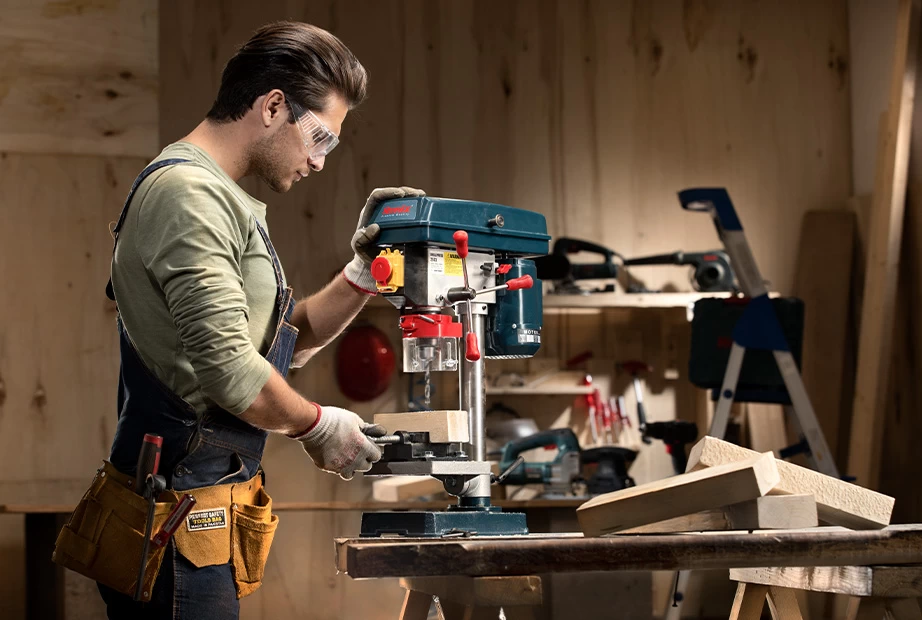  a man working with a bench-top drill press