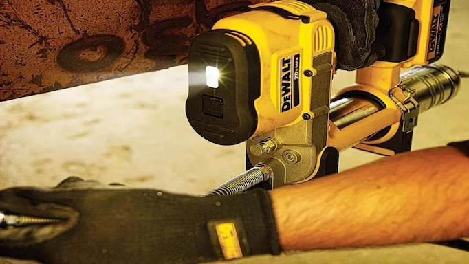 A cordless grease gun is being used