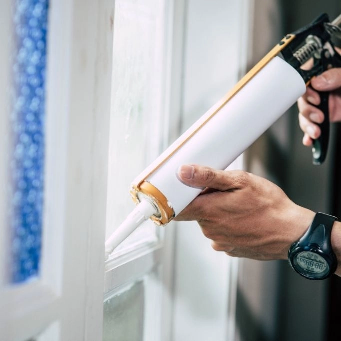 picture of a caulking gun fixing a window