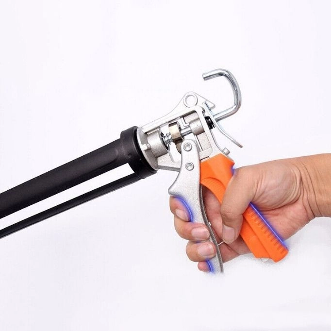picture of a hand holding a caulking gun 