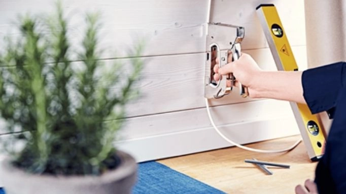 A man using a staple gun on wires