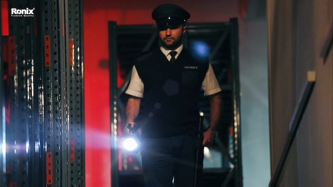 A security guard using a spotlight