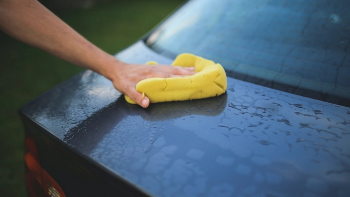 A car is being dried using a sponge