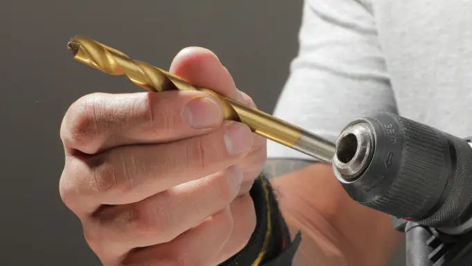 A man inserting one of the Ronix best drill bits for metal in a drill