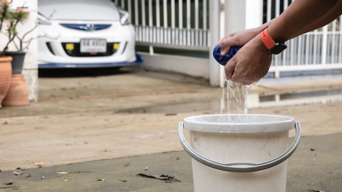 Putting a towel in a bucket for washing cars at home