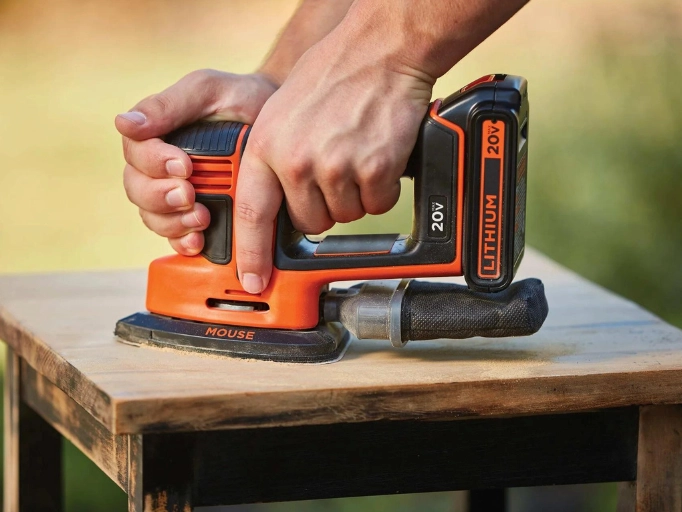 A cordless Sander on a wooden table