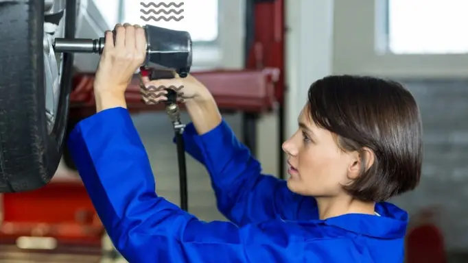 A woman using a non-ergonomic impact wrench on a tire